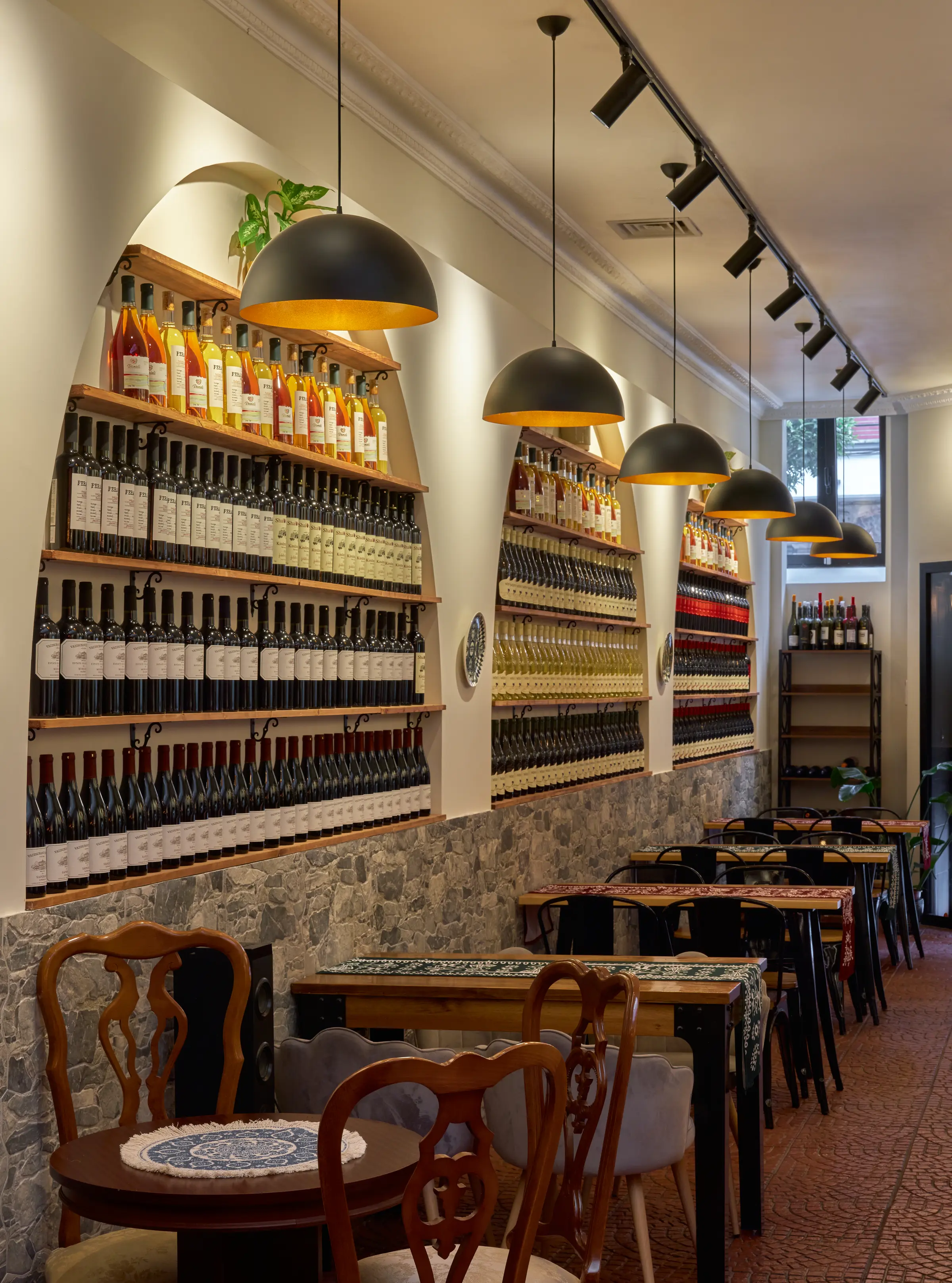The cellar arches seen on the diagonal, with laid tables and pendant lamps in the foreground